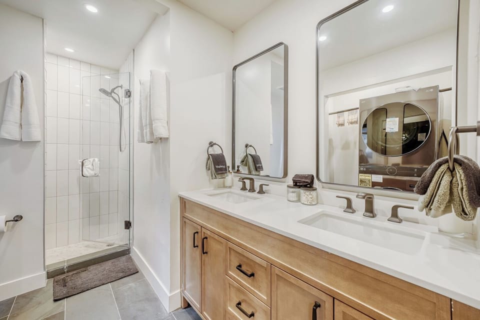 Start and end your day in comfort ✨. With a double vanity, sleek finishes, and a spacious walk-in shower, this bathroom brings a touch of boutique luxury to your stay 🛁