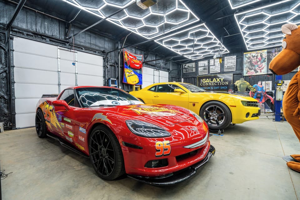 Epic themed garage with show cars and dramatic LED ceiling lighting