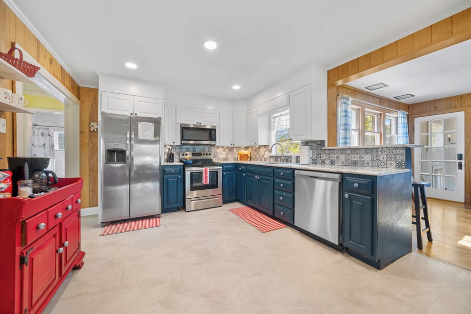 Bright, updated kitchen with stainless appliances and stylish blue cabinetry
