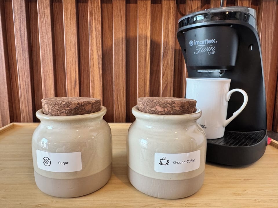 Cozy coffee station with brewer, mug, sugar and ground coffee ready.