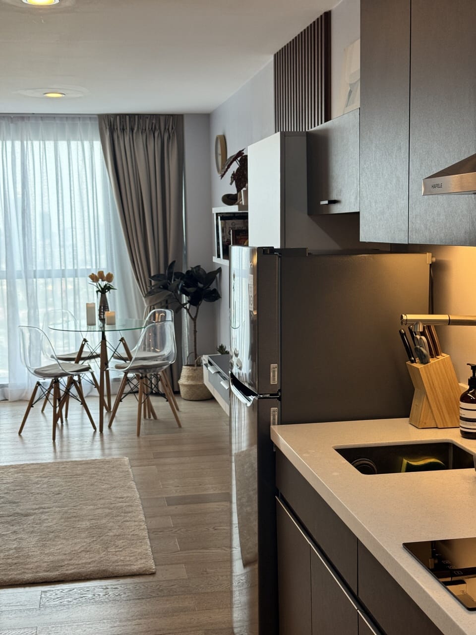 Modern open kitchen and chic glass dining, bright floor-to-ceiling windows