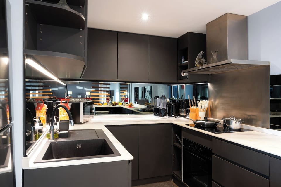 【Kitchen】Franke cooktop, hood, oven, and dishwasher with the same skyline running behind the counter. Cook a real meal and look out at the city while you do it. Built for long stays.