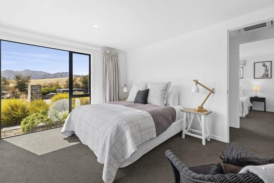 Light-filled bedroom featuring stunning alpine views and direct outdoor access.
