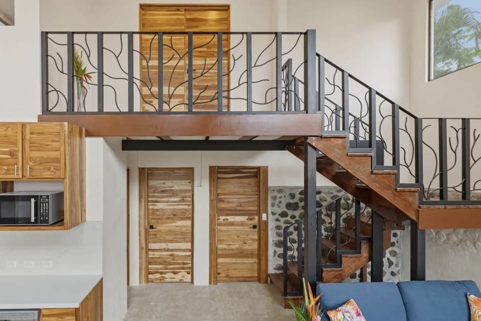 The open layout connects the kitchen, living room, and upstairs bedrooms.