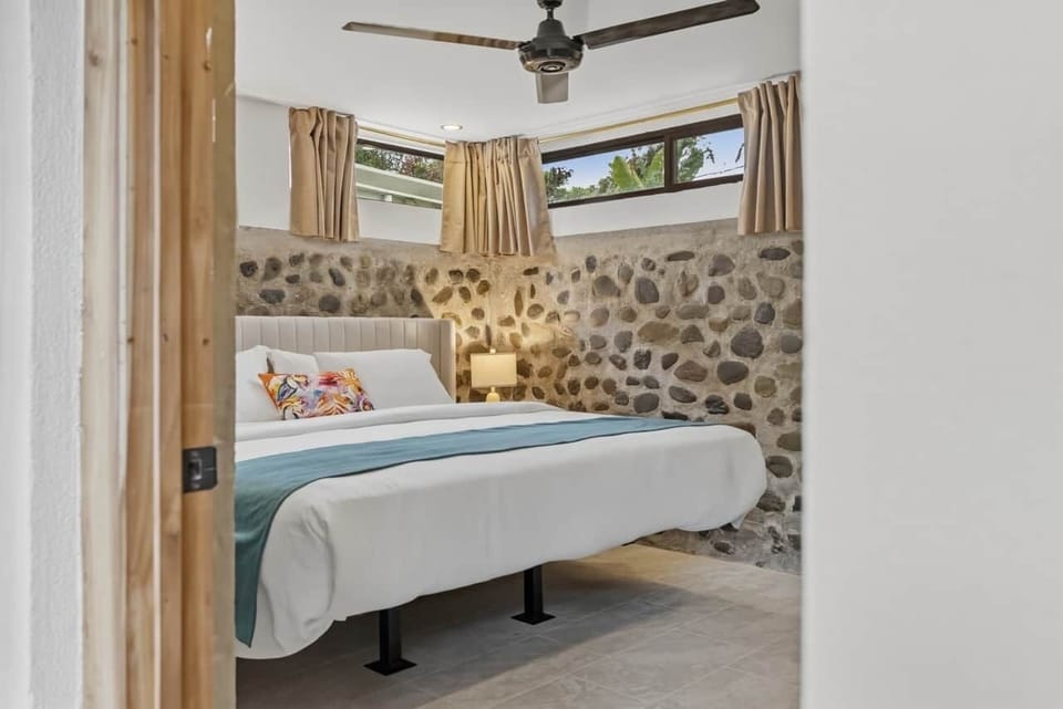 Cozy downstairs king bedroom with beautiful natural stone accents.