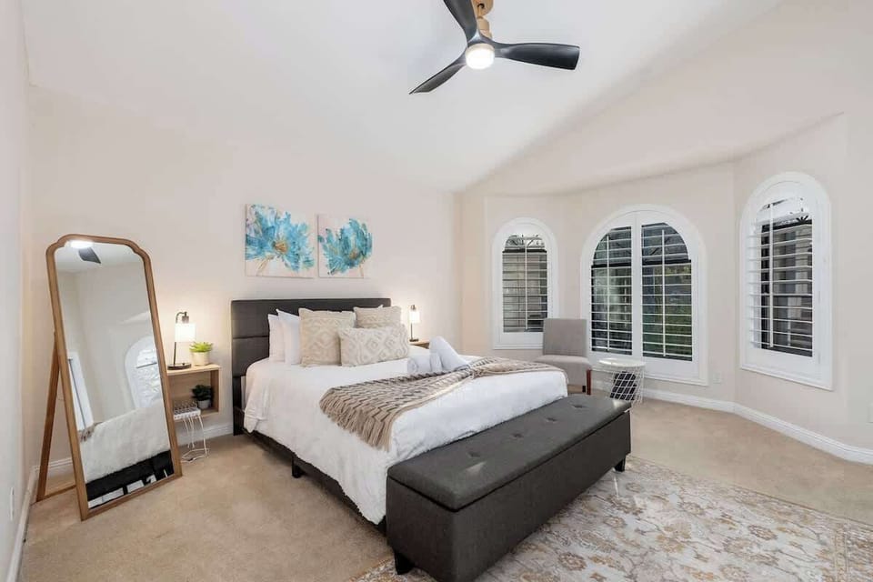 Your restful retreat features a plush king bed, vaulted ceilings with a modern fan, and elegant arched windows that fill the space with natural light.