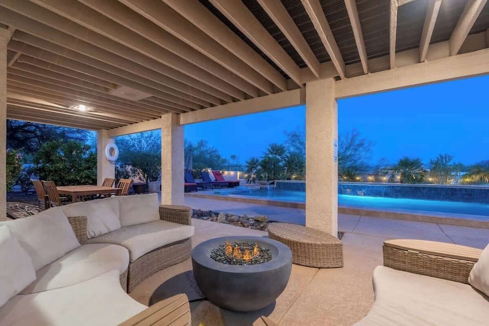 Sink into plush seating by the fire pit as twilight paints the sky, your private pool glowing just steps away—an inviting retreat for unforgettable evenings.