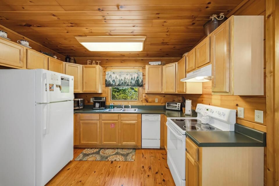 Cozy wood-paneled kitchen with full-size appliances and rustic charm