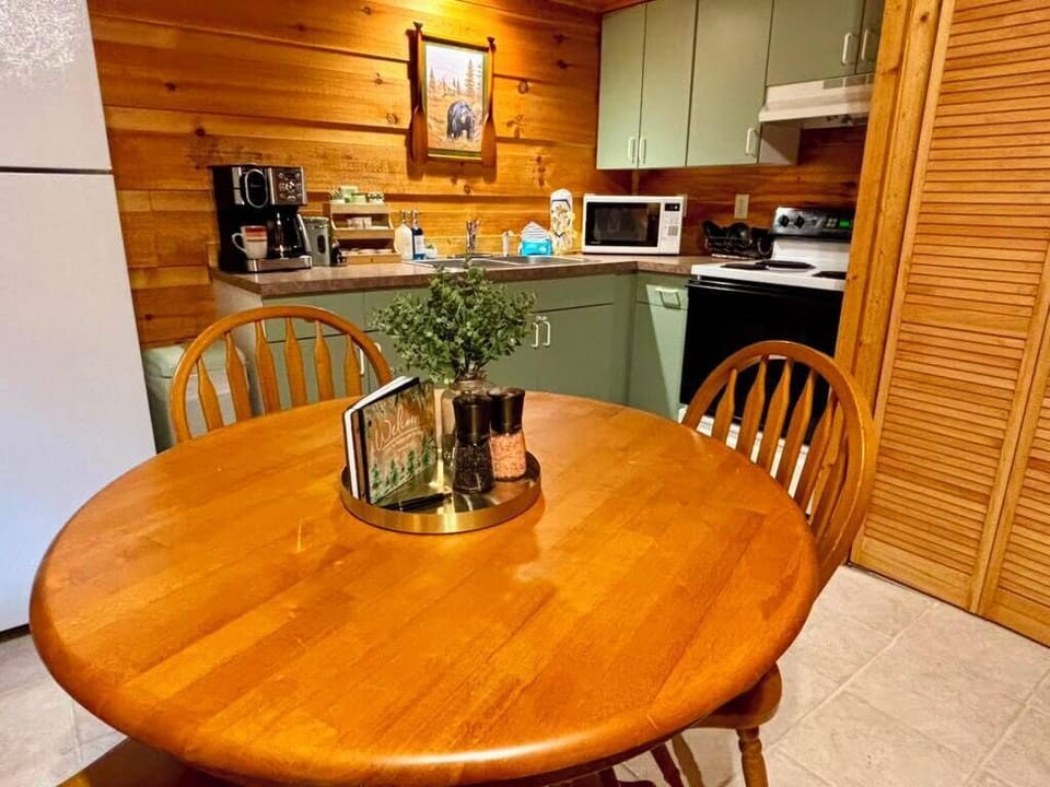 Cozy woodsy kitchen with dining table, coffee station, and cabin charm