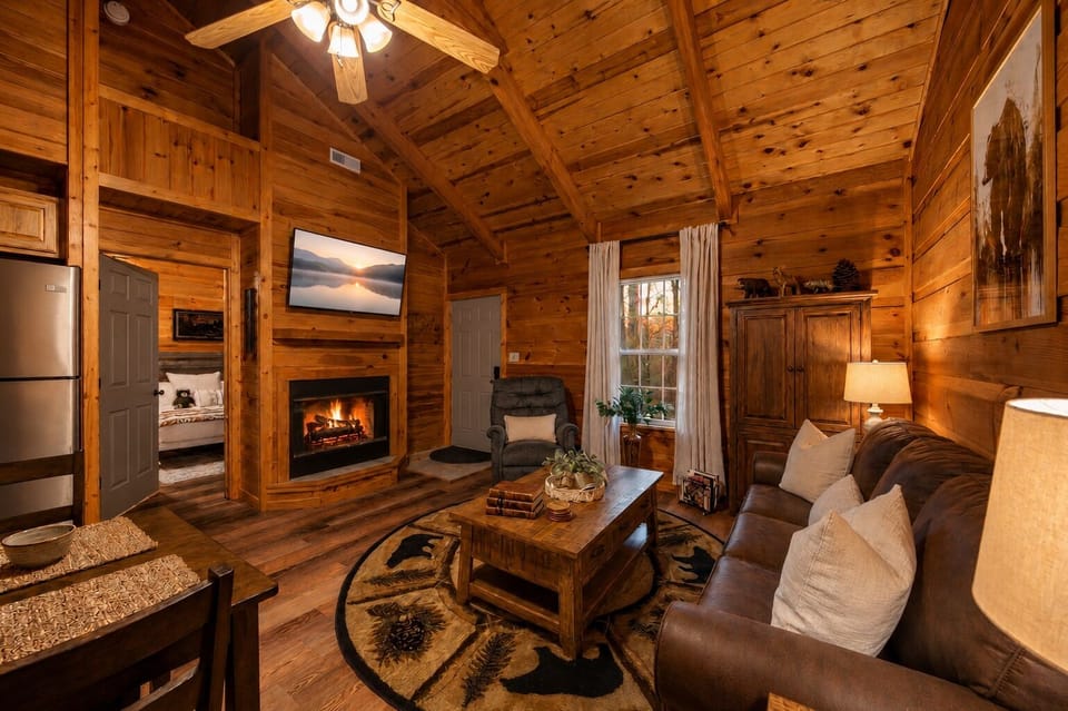 Cozy rustic living room with fireplace, TV, and soaring wood ceilings