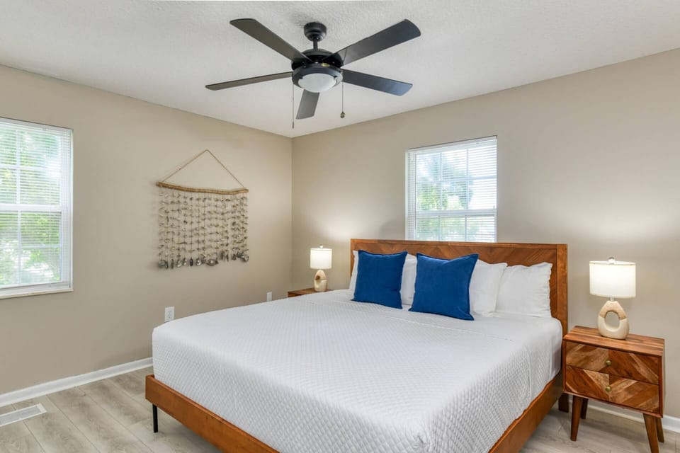 The second-floor king suite features brand-new furnishings, relaxing coastal decor, soft linens, plenty of storage space, and access to the bathroom.