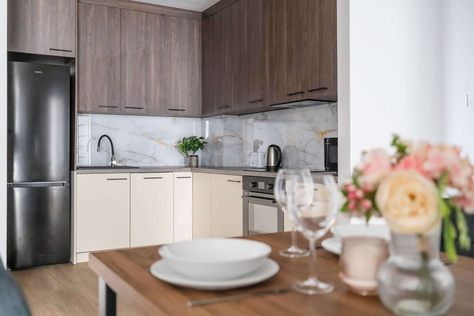 A closer look at the fully equipped kitchen and dining area with stylish table settings. The space is designed for comfortable cooking and shared meals.