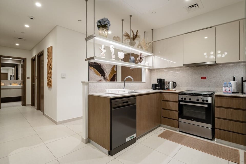 Fully equipped modern kitchen featuring a large refrigerator, oven, microwave, electric kettle, toaster, and dishwasher. Thoughtfully designed with everything you need to prepare meals and enjoy a comfortable home-away-from-home experience.