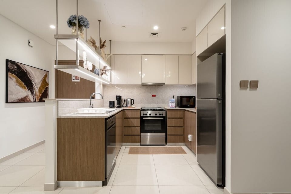 Fully equipped modern kitchen featuring a large refrigerator, oven, microwave, electric kettle, toaster, and dishwasher. Thoughtfully designed with everything you need to prepare meals and enjoy a comfortable home-away-from-home experience.
