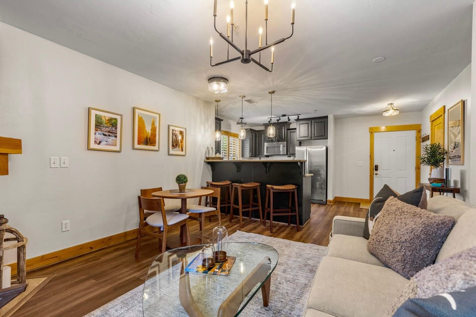 Unwind in your cozy open-concept living space, where warm wood accents and comfortable seating invite you to relax after exploring. The fully-equipped kitchen and dining area make it easy to enjoy meals together.