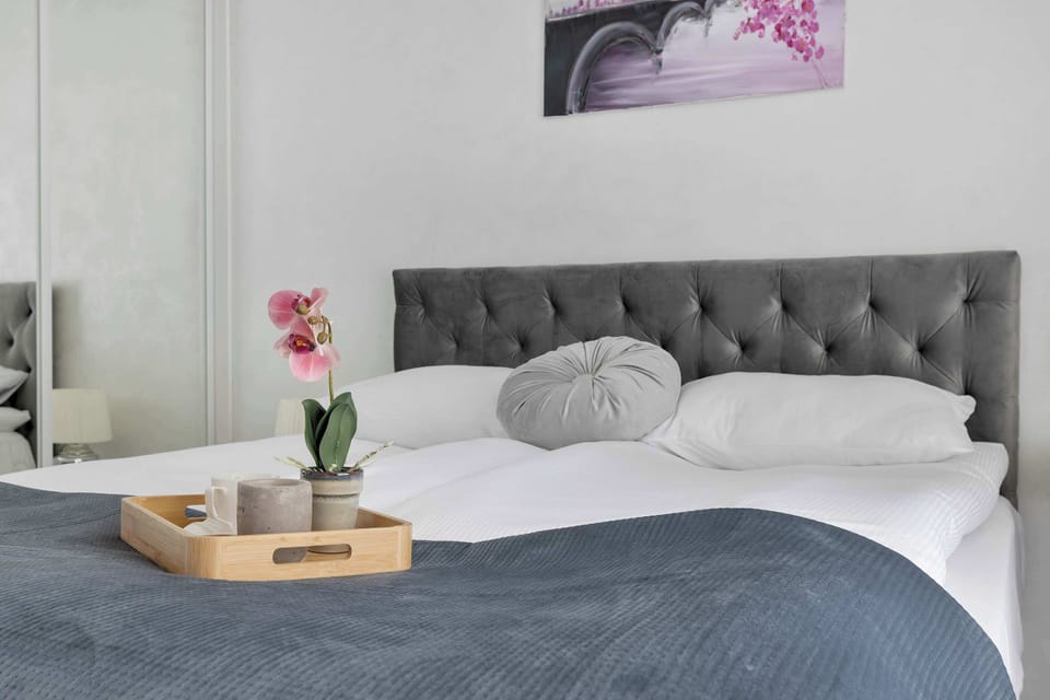 A wooden breakfast tray rests invitingly on top of the neatly made double bed. This cozy setup highlights the comfort and hospitality of the sleeping quarters.
