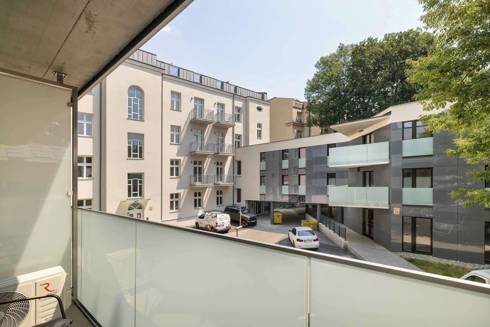 Looking out from the balcony reveals a peaceful perspective of the modern residential estate. The clean layout of the courtyard emphasizes privacy and contemporary urban living.
