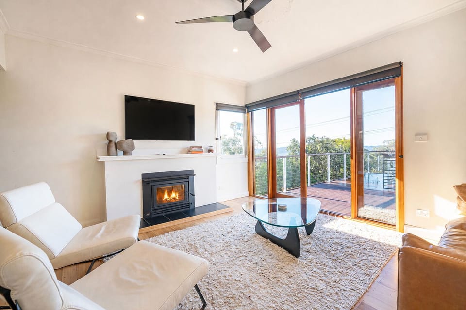 The living area opens effortlessly onto the upper deck, inviting you to enjoy panoramic Derwent River views and fresh hillside air throughout the day.