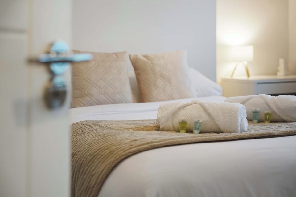 On the downstairs right-hand side, the double bedroom is furnished with a wardrobe, desk, hair dryer, towels, mirror, and decorative wall art.