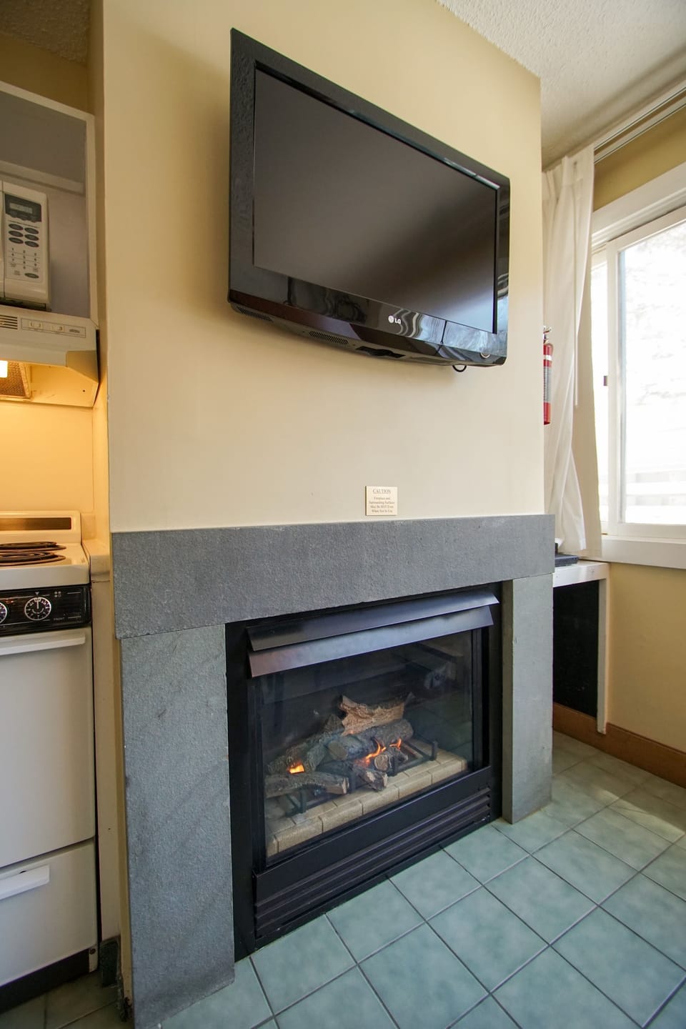 Enjoy entertainment on the wall-mounted TV, perfectly positioned near the cozy fireplace for a night in.