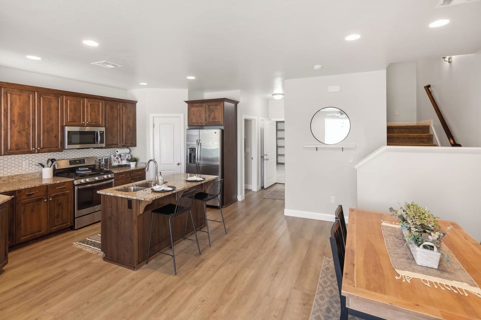 Well-equipped kitchen with island seating, stainless appliances & dining