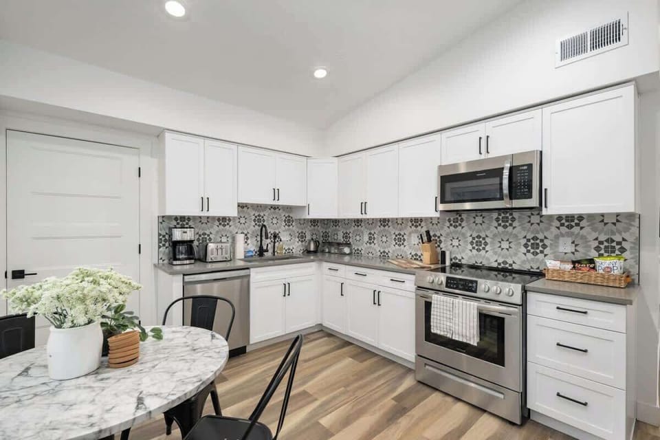 Fully-stocked, open kitchen with table and seating for four. 