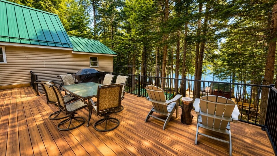 Enjoy outdoor dining and lake views from the spacious deck surrounded by towering pine trees.