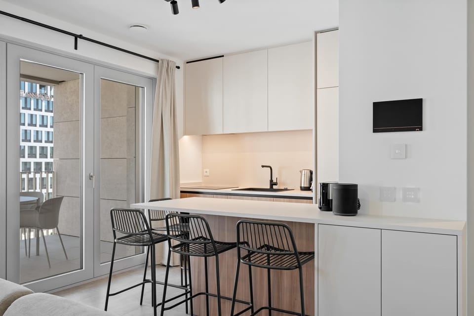 Modern kitchen with bar seating, balcony access, and everything needed for a comfortable stay.
