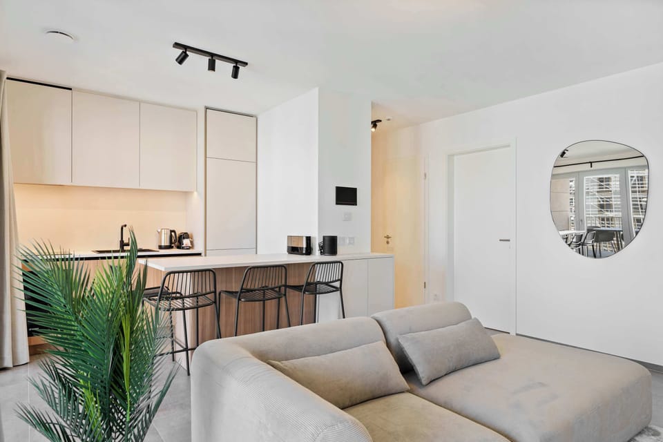 Cozy living space with sofa, TV, kitchen, and dining area, ideal for business trips or city breaks.