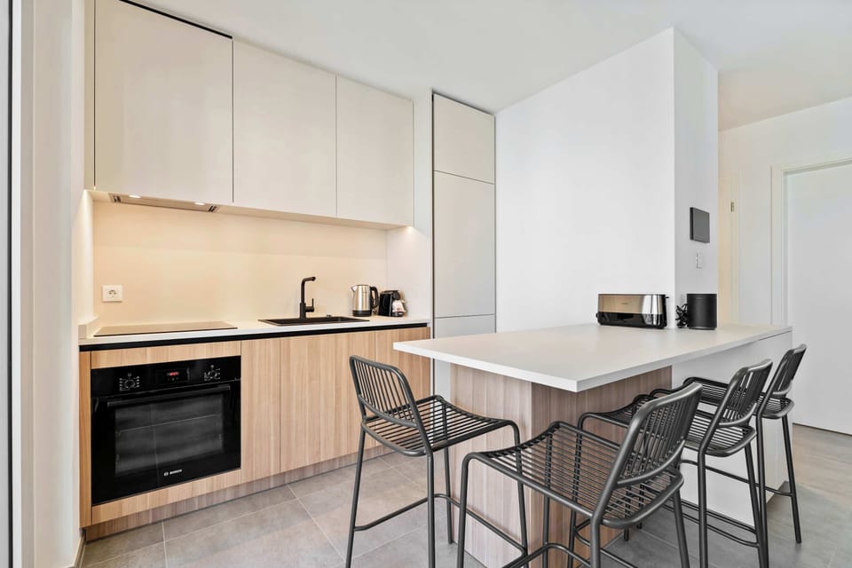 Fully equipped kitchen with oven, stove, dishwasher, and dining counter for easy meals at home.