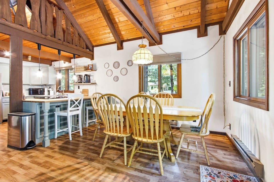 Share memorable meals in a warm dining space filled with natural light, cabin charm, and peaceful wooded views.