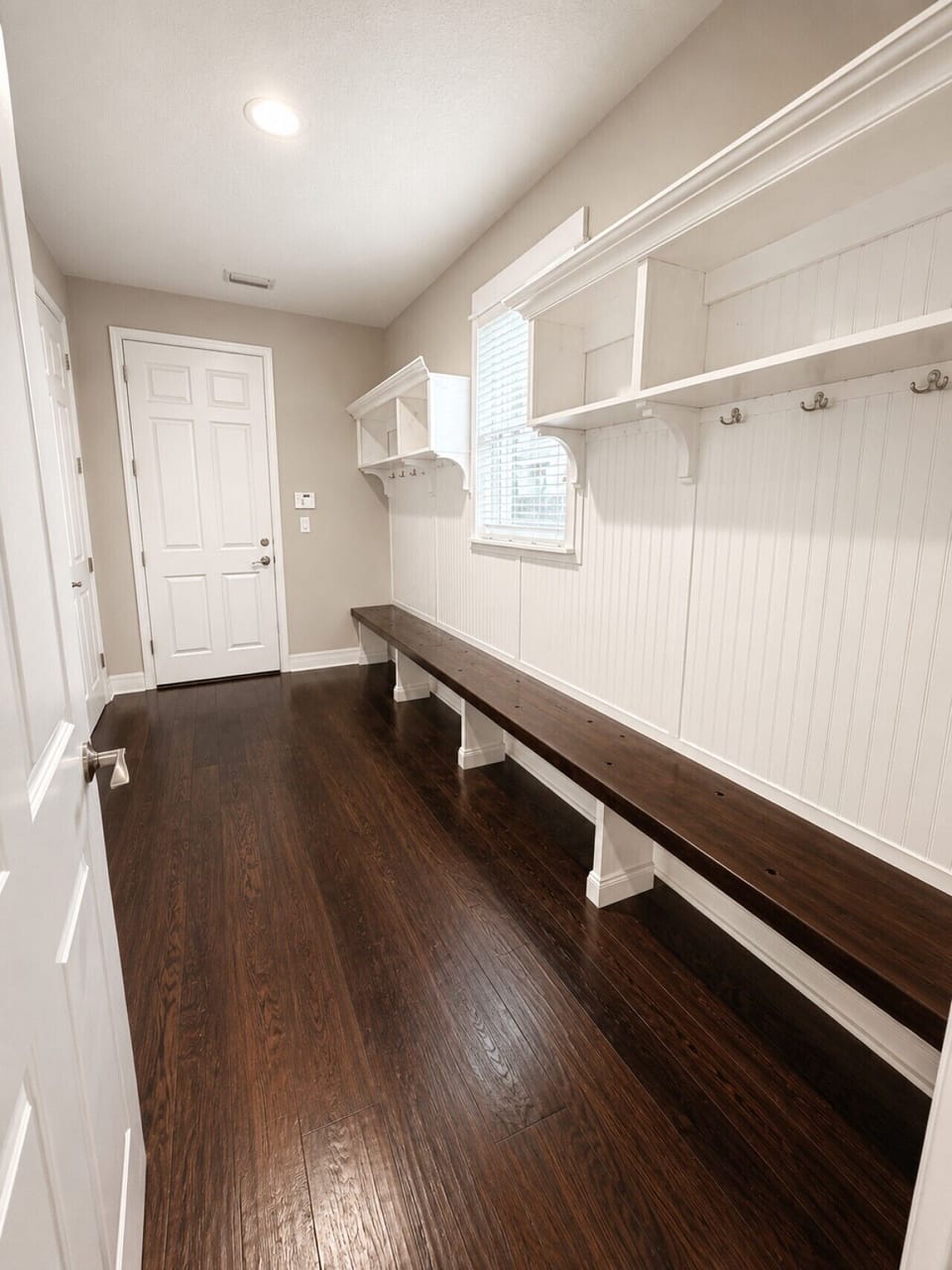 Large mudroom with built-in bench, storage cubbies, and hooks to keep shoes, towels, and beach gear organized
