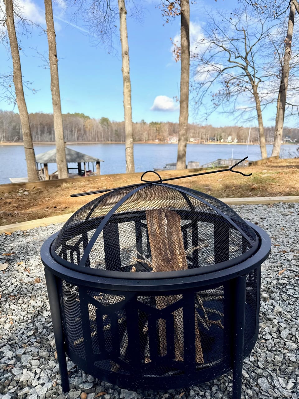 Lakefront fire pit with dock views—perfect for cozy nights outdoors.