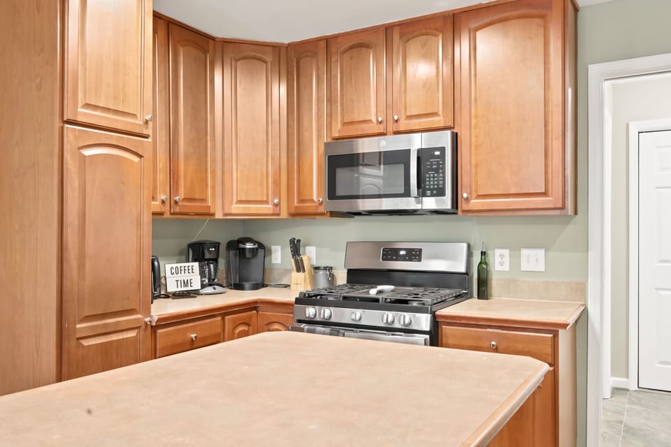 Warm wood cabinets wrap around this bright kitchen, anchored by an island made for casual bites and a gas range ready for serious mountain-cabin cooking.
