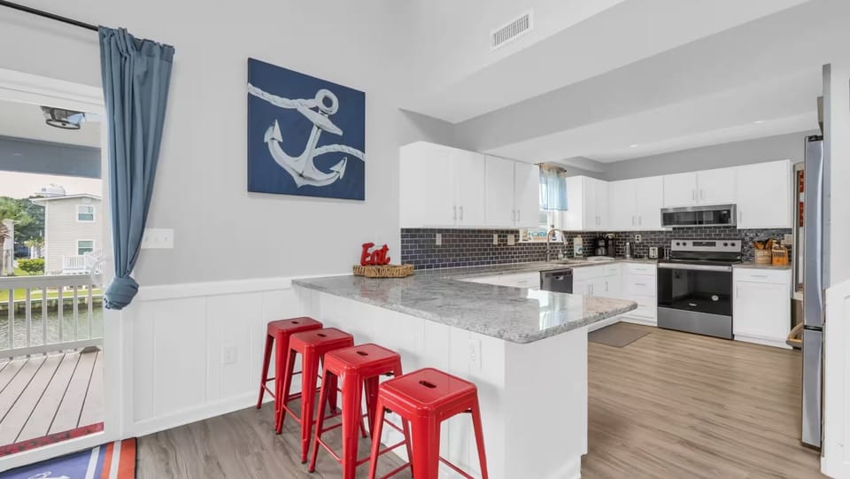 Spacious kitchen island with breakfast bar stools, perfect casual dining spot.