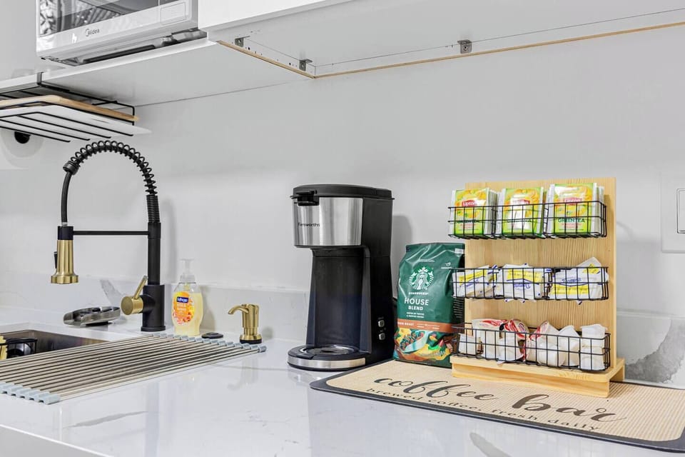 The kitchen offers a coffee maker, complimentary coffee, tea bags, and other essentials. The sink offers both hot and cold water, and dish soap is conveniently provided, ensuring everything you need for a comfortable stay is at your fingertips. 