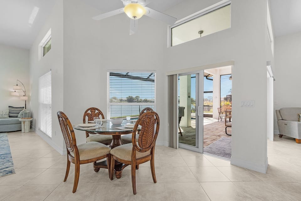 A bright, secondary dining nook sits perfectly positioned by the glass doors, offering an intimate spot to enjoy a meal with a view.