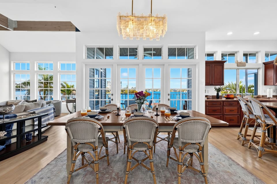 Large glass French doors frame stunning waterfront views directly from the formal dining area.
