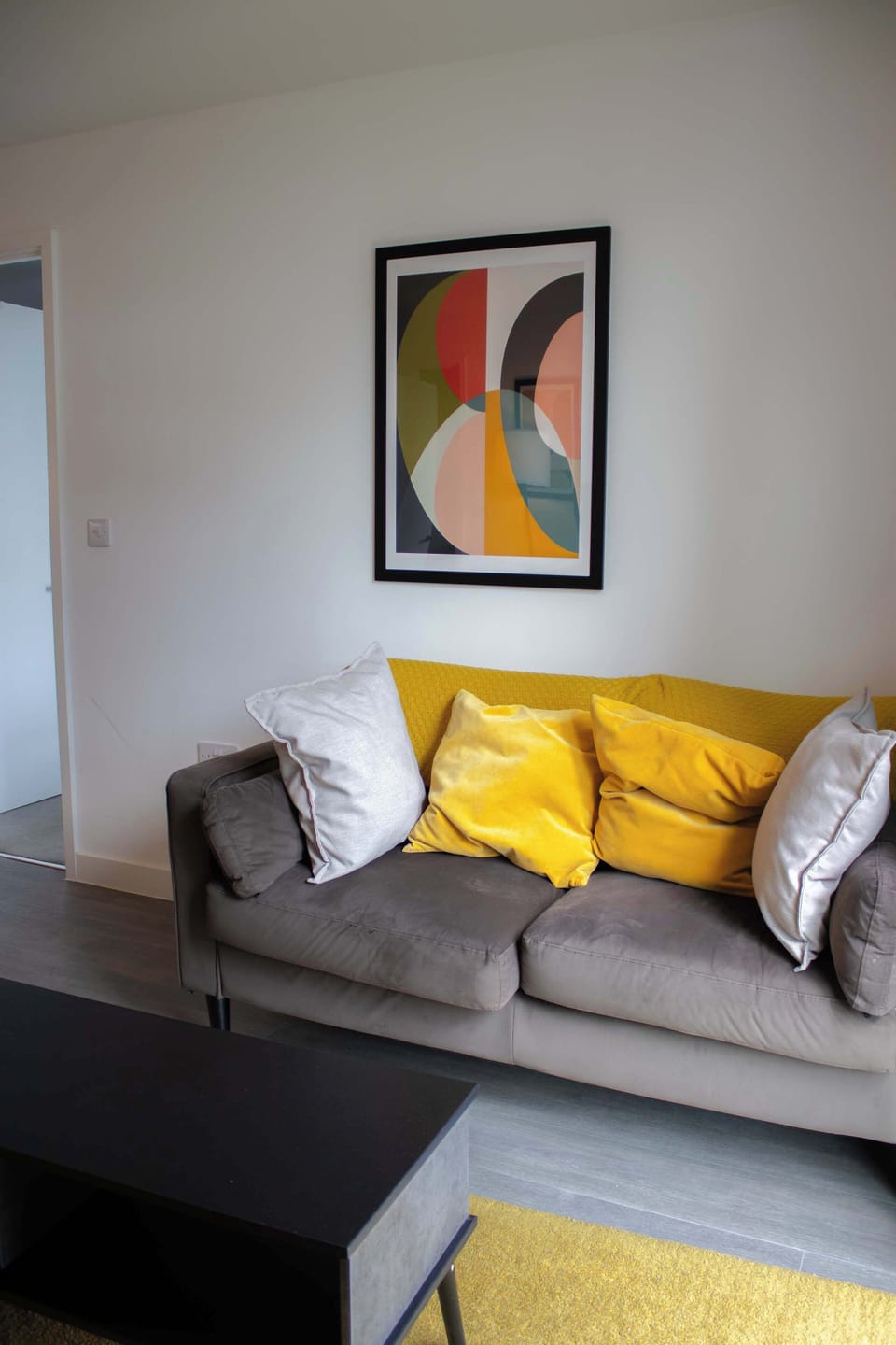 The modern open-plan living area features a comfortable lounge, fully integrated kitchen, and dedicated dining space. Whether catching up on work, watching TV, or sharing a meal, the layout is designed for everyday comfort.
