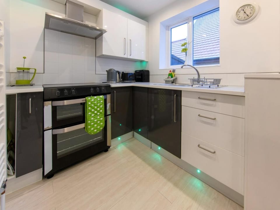 Open-plan kitchen with breakfast bar and utility area