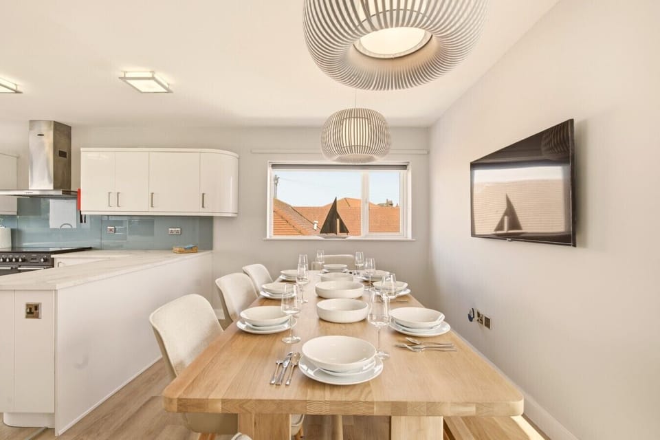 Modern dining space with ample seating beside a fully equipped kitchen