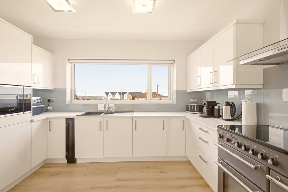 Bright contemporary kitchen with sleek finishes and views towards the coast