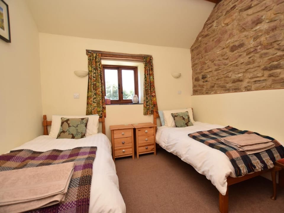 Twin bedroom with charming stone wall displayed