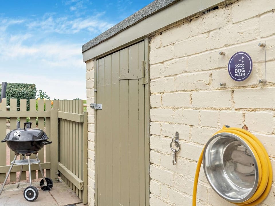 Dog wash area, with tethers and a hose which can be connected to the warm outside tap