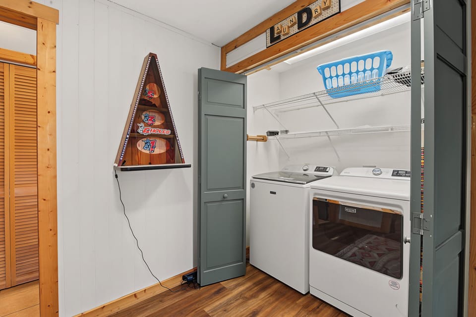 Your in-unit laundry area makes staying fresh effortless, with a washer and dryer tucked into a tidy space beneath warm wood-beam accents.