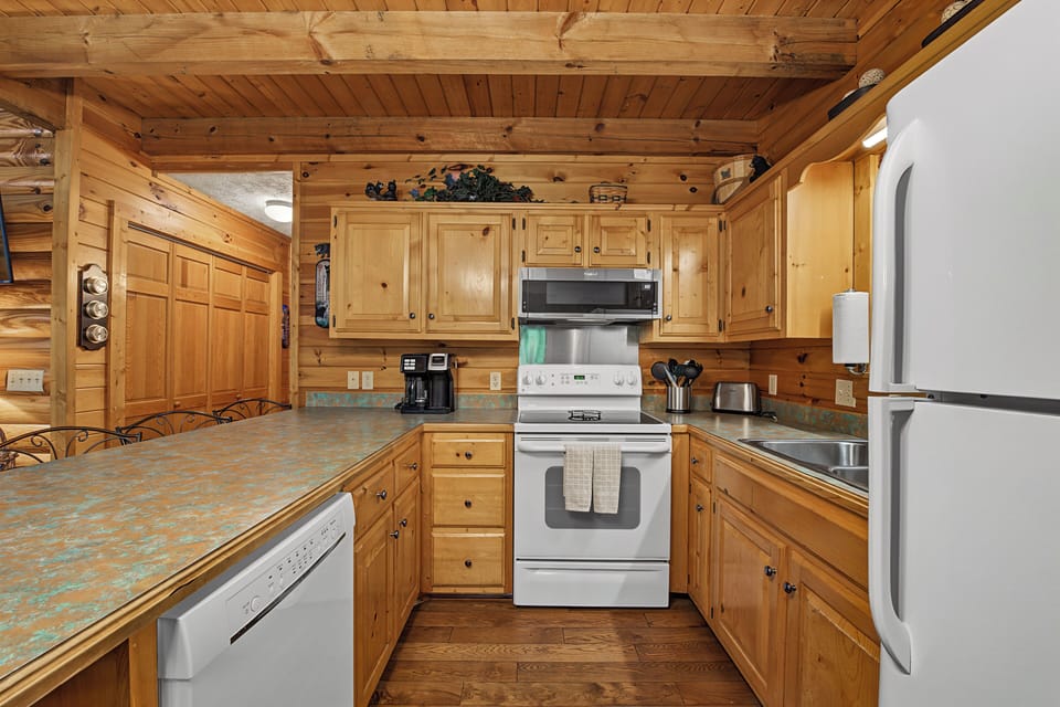 Your fully equipped kitchen features warm wood cabinetry, full-sized appliances, and everything you need to prepare meals during your stay in this cozy mountain retreat.