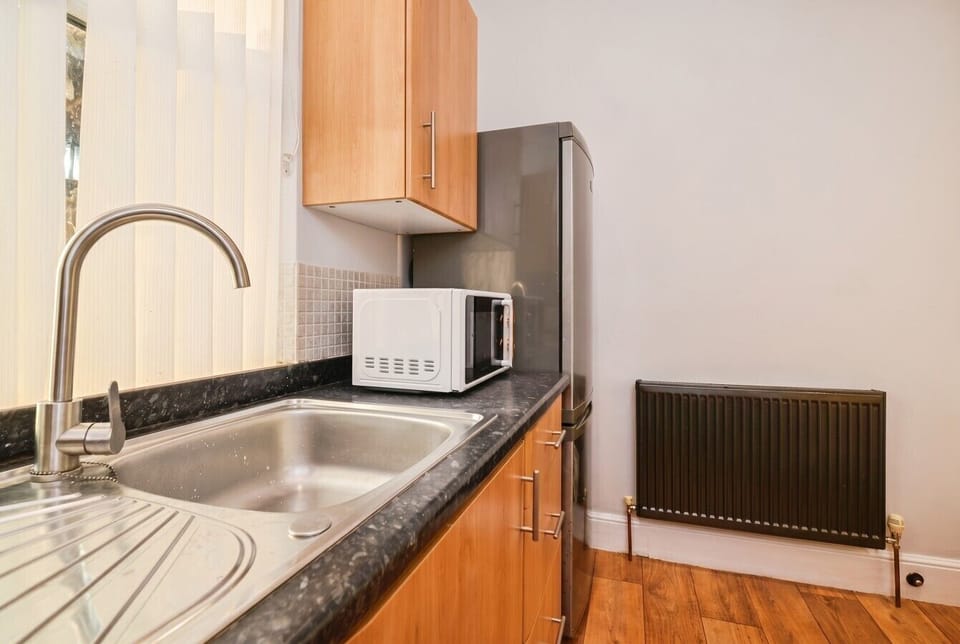 Handy kitchen area with a stainless sink and microwave for easy meals.
