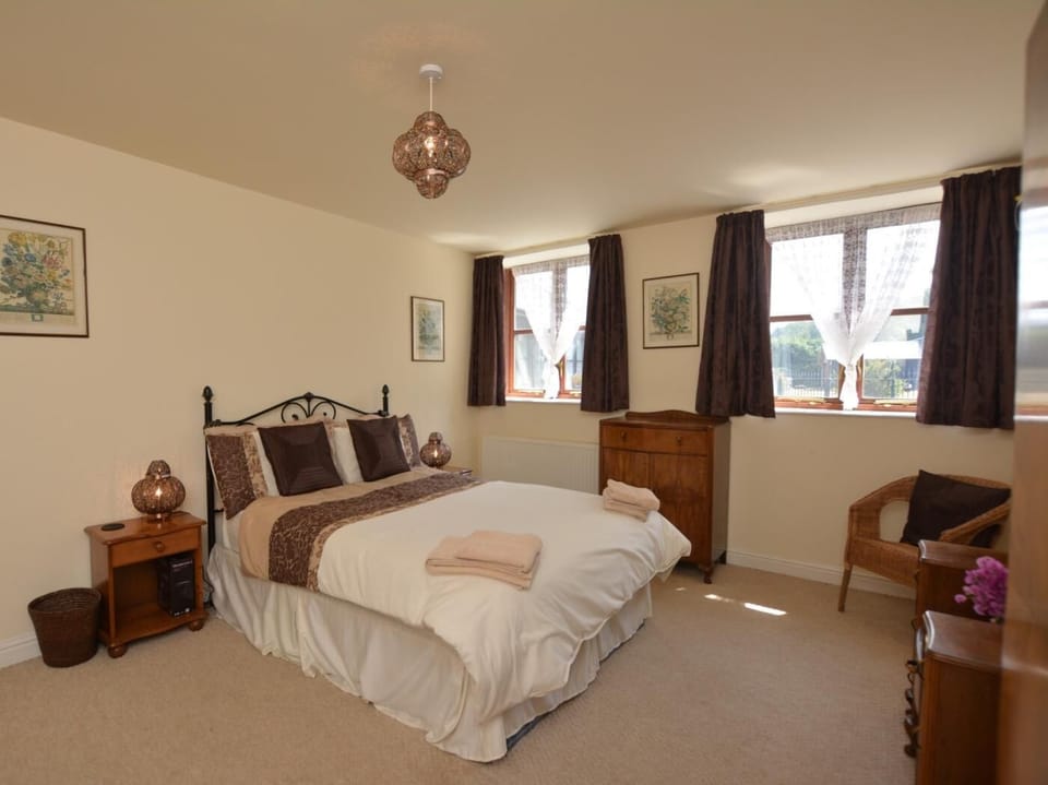 Spacious double bedroom with sofa and views over the courtyard garden