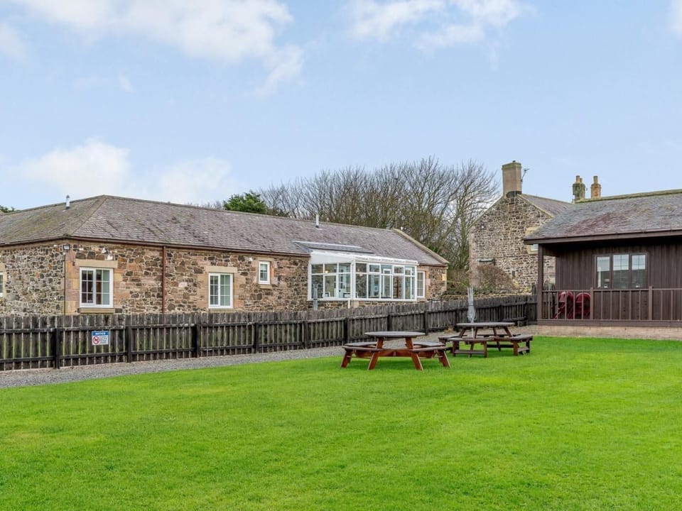 View of the property from the green with shared pinic benches 