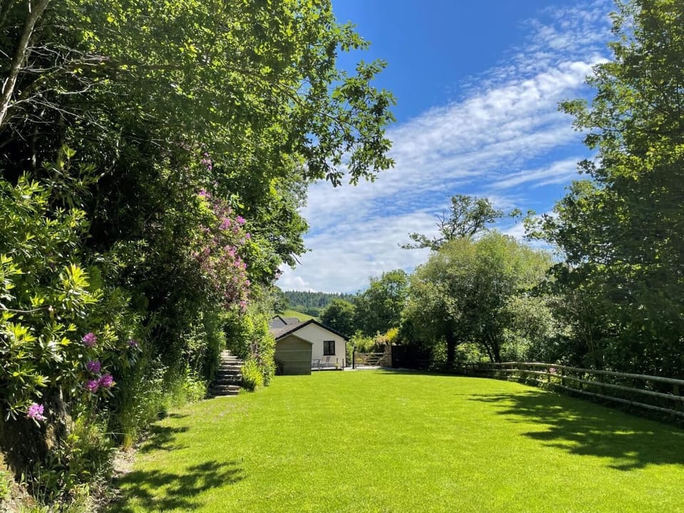Large and private garden with pathway leading to woodland and riverside walks